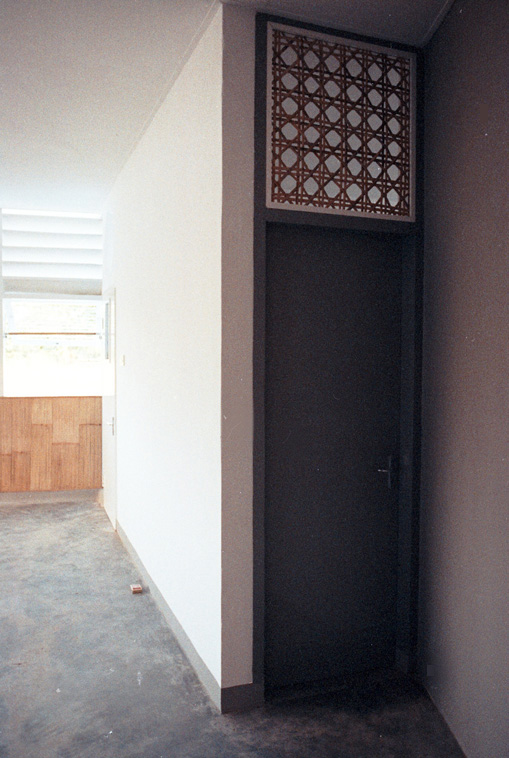 Détail haut de porte en canevas rotin pour ventilation naturelle